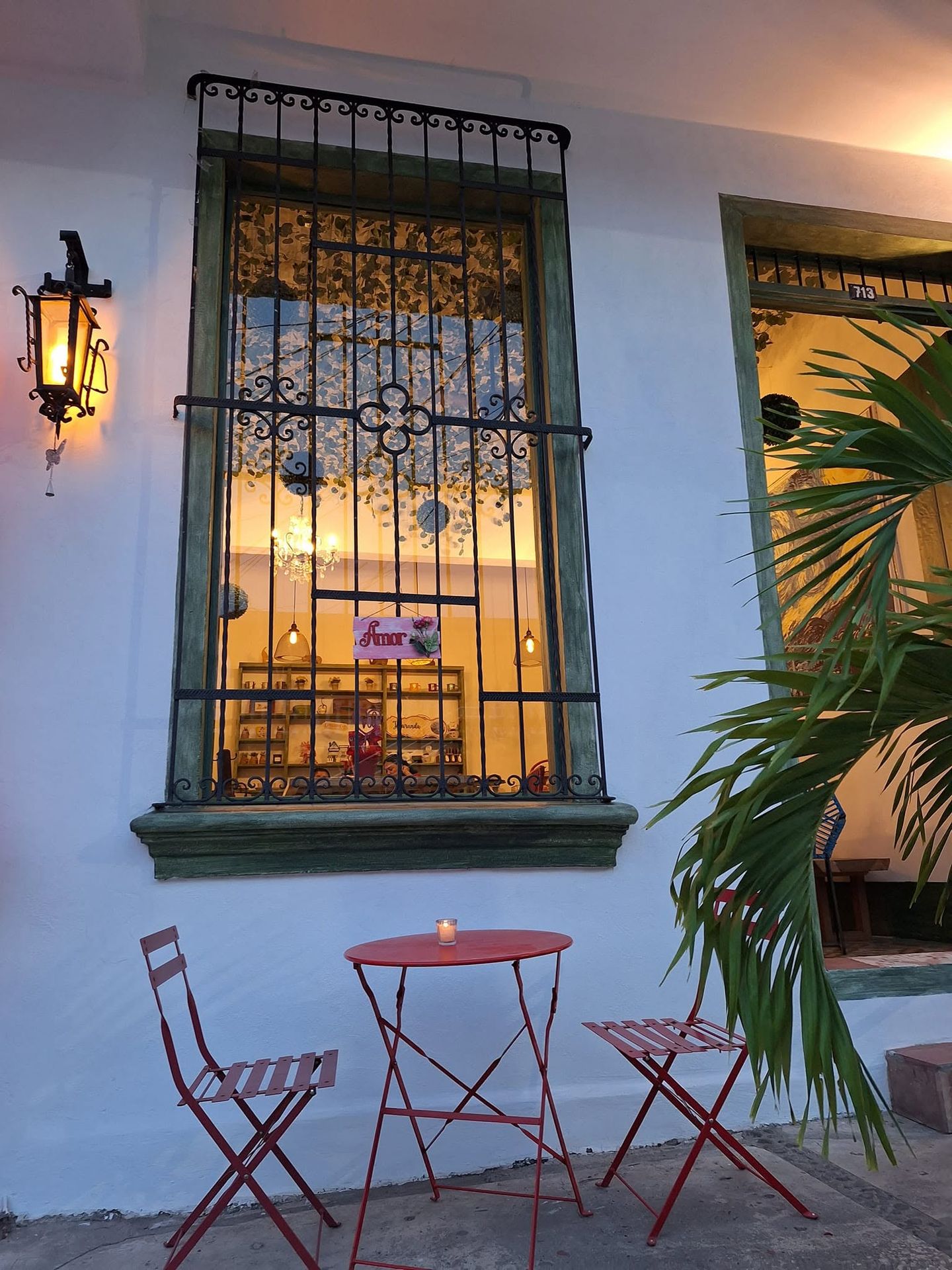 Ventana con herrería y lámpara colonial en la fachada
