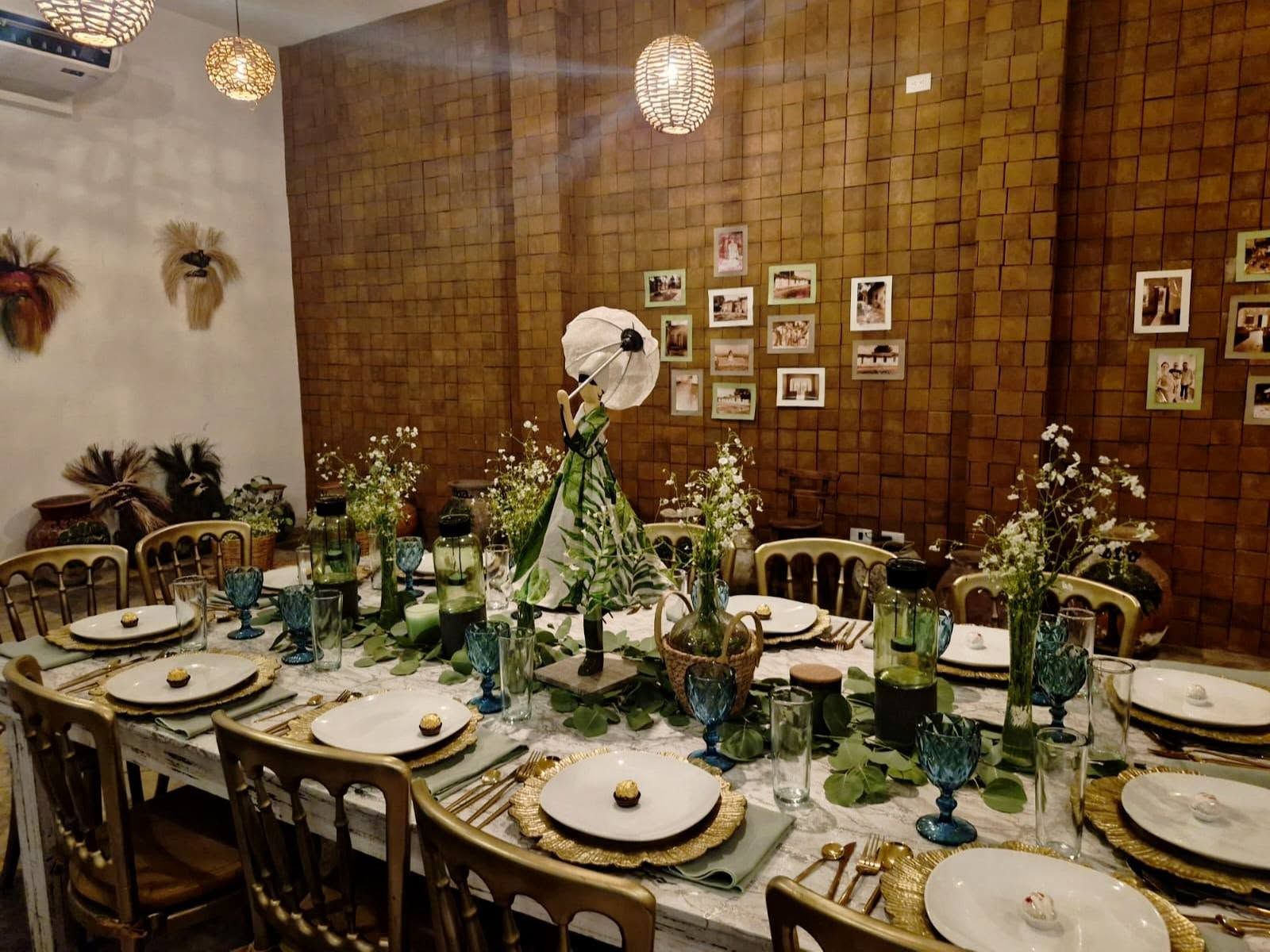 Salón montado para una cena con mesa larga y flores